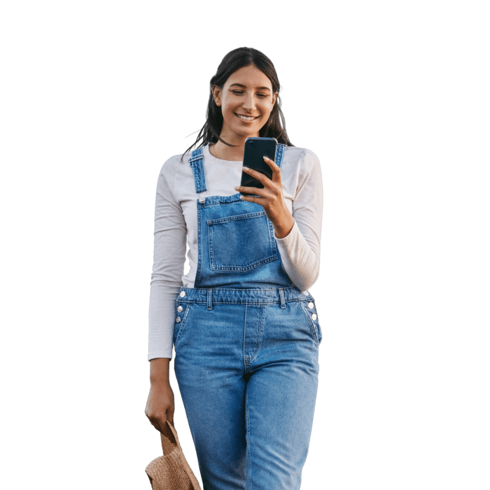 Mulher sorrindo usa celular com uma mão e segura um chapéu com a outra. Imagem representa o plano TIM Fixo Rural.